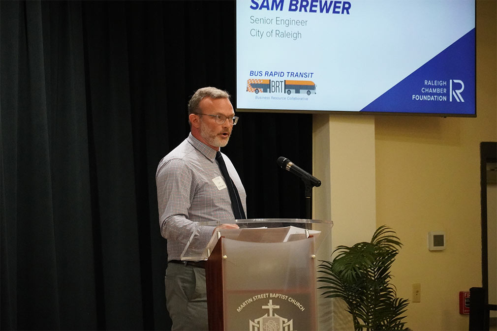 Photo of Sam Brewer speaking at a podium